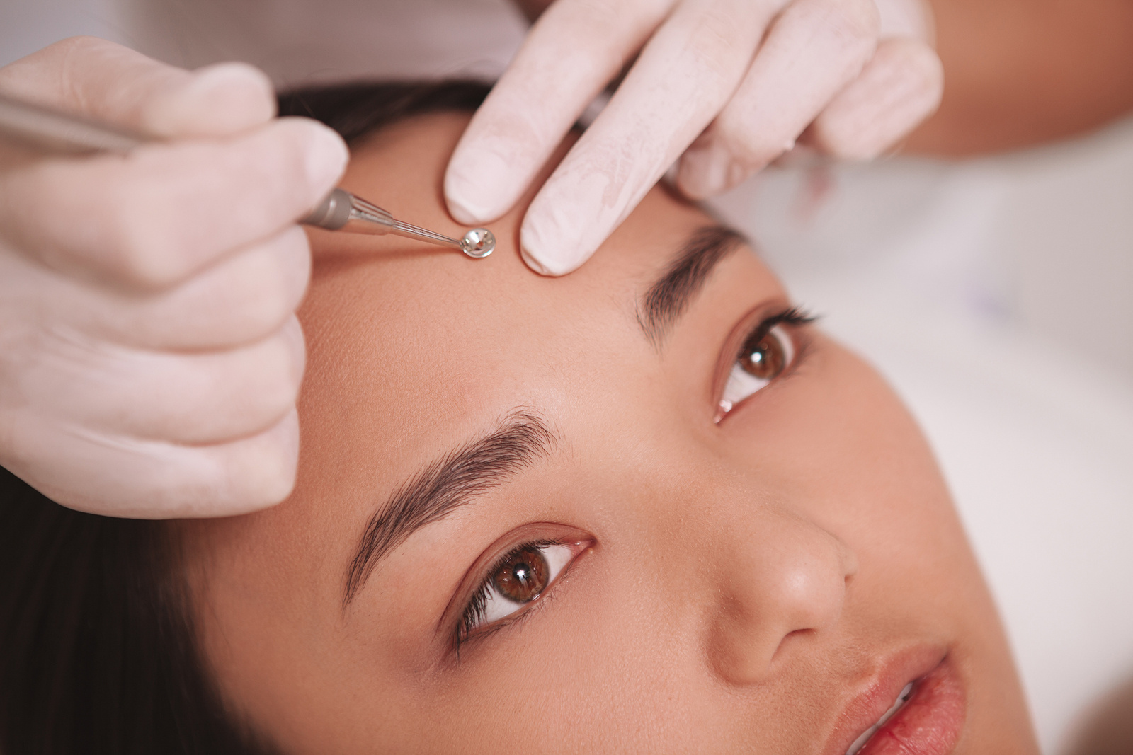Beautiful Asian woman getting skincare treatment at beauty salon